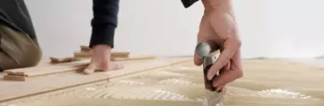Worker applied adhesive for parquet. Home renovation