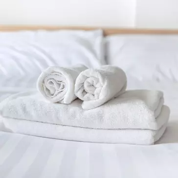 Clean white towels folded on a bed