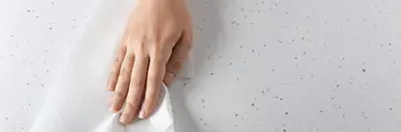 Woman wiping light table with paper towel