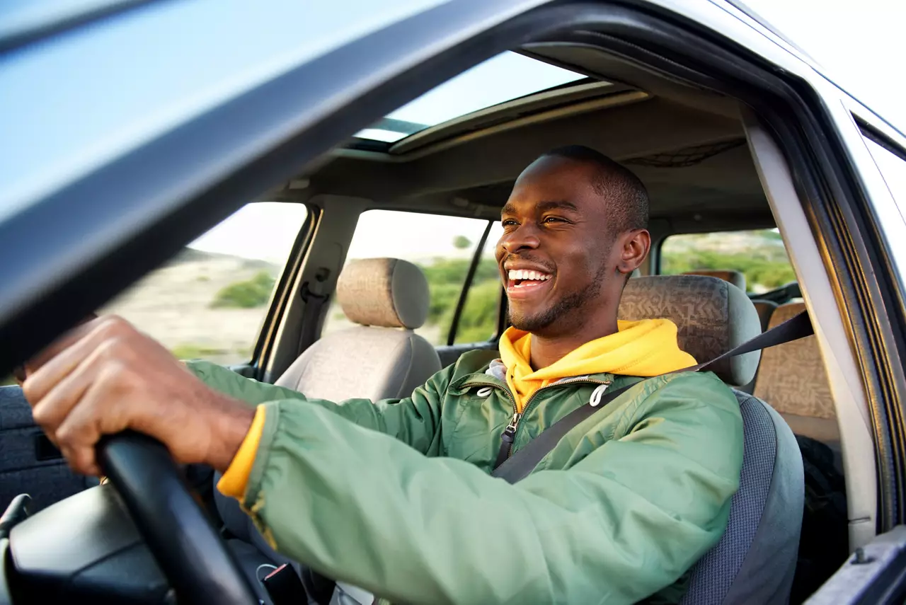 Side portrait of happy  man driving ca