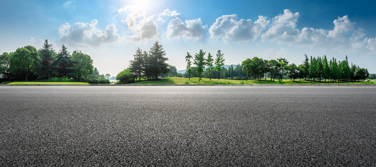 Country asphalt road and green woods nature landscape in summer.