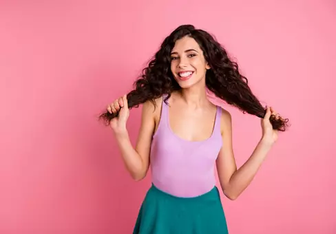 Photo of nice cute dreamy, girl holding her hands wearing green skirt while isolated with pink background