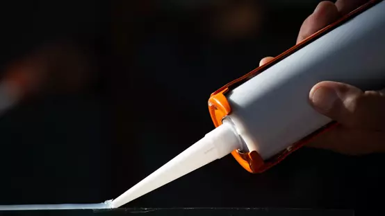 Silicone adhesive being applied with tool