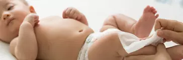 Mom cleaning up and wipe body baby by wet tissue when changing nappies or diaper 