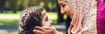 Portrait of religious enjoy happy love asian family arabic muslim mother and little muslim girls child with hijab dress smiling and having fun touching face with cute kid daughter moments good time