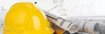 Yellow helmet, calculator, level and project drawings