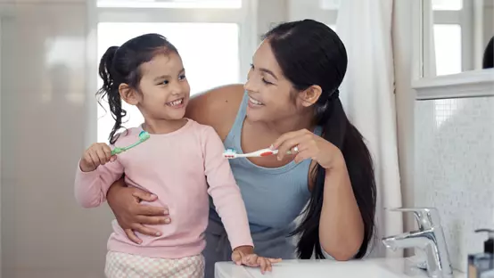 Mother and daughter brushing teeth 