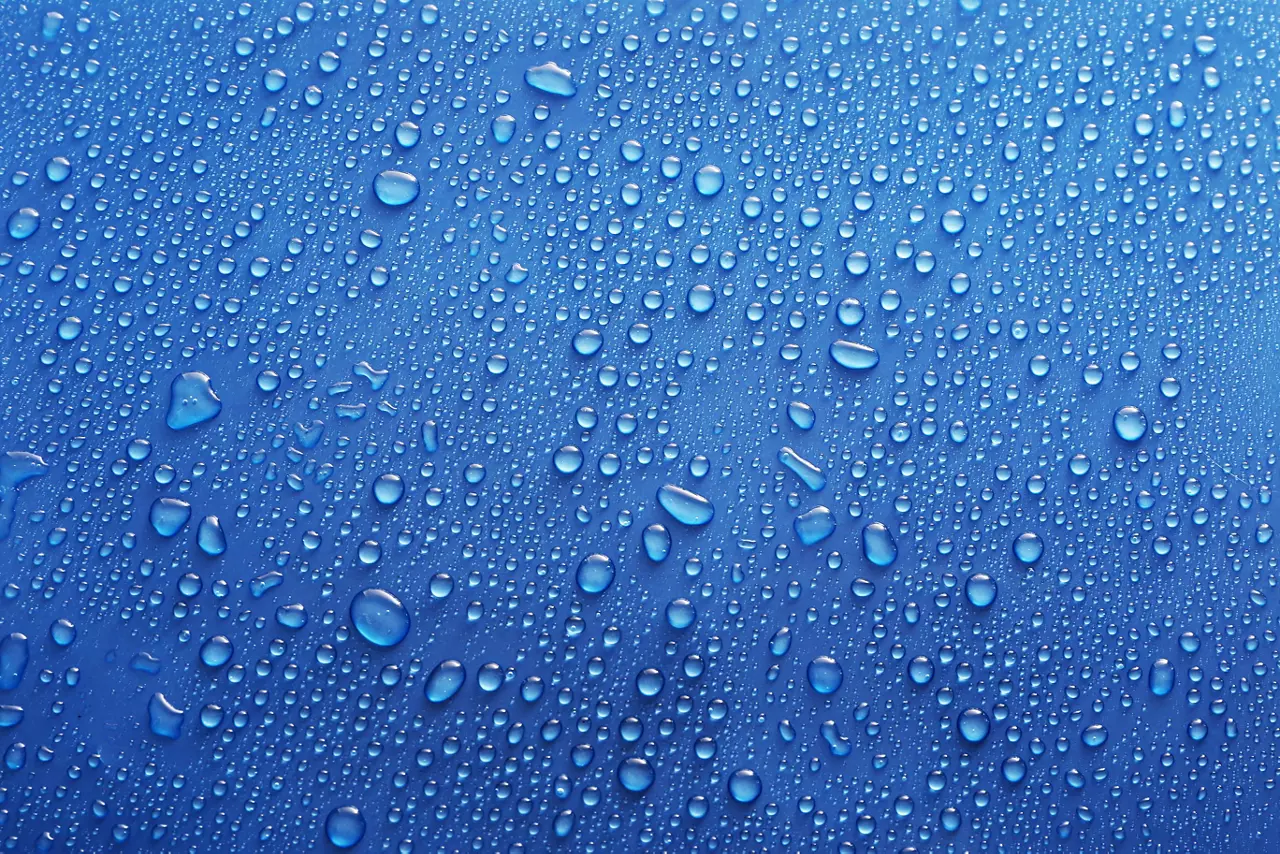 Water drops on glass on blue background.