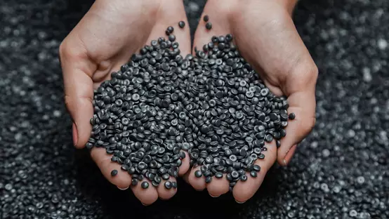 Hands holding colored PCR resin pellets