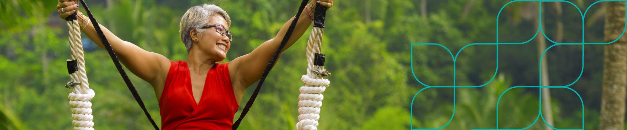 Woman riding rainforest swing in red dress