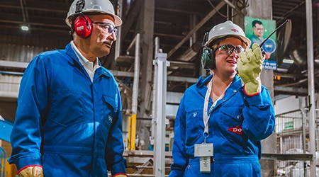 Two warehouse workers in full PPE