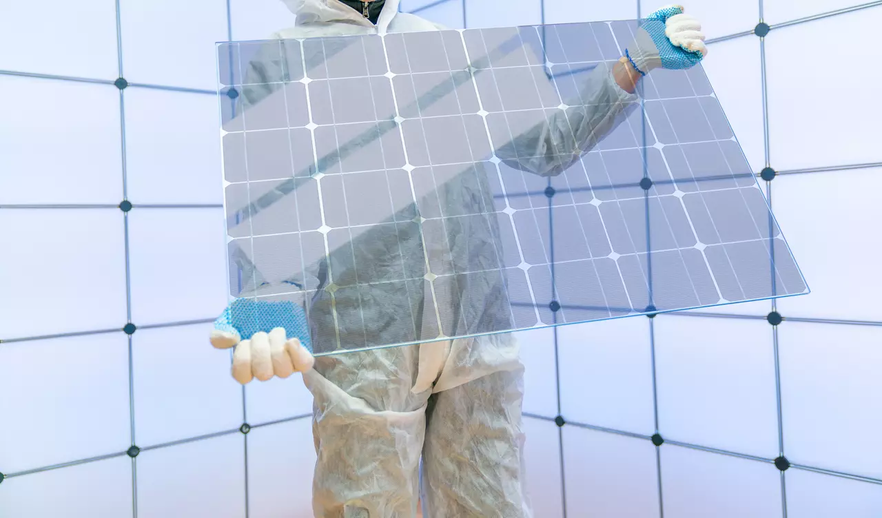 Translucent solar panels for use as window glass. Photovoltaic glass is  most cutting-edge new solar panel technology that   scope of solar. Transparent solar panel in the hands of a worker