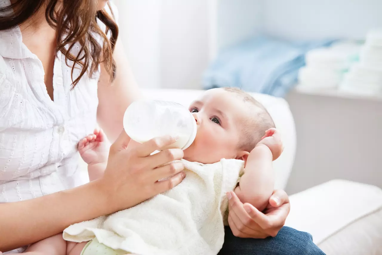 mother feeding her adorable son in the kitchen.